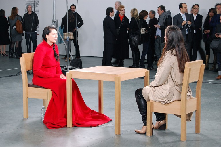  Marina Abramović, The Artist is Present, 2010, Museum of Modern Art, New York, 9 March – 31 May 2010. Image courtesey of Andrew Russeth [CC BY-SA 2.0 (https://creativecommons.org/licenses/by-sa/2.0)], via Wikimedia Commons.