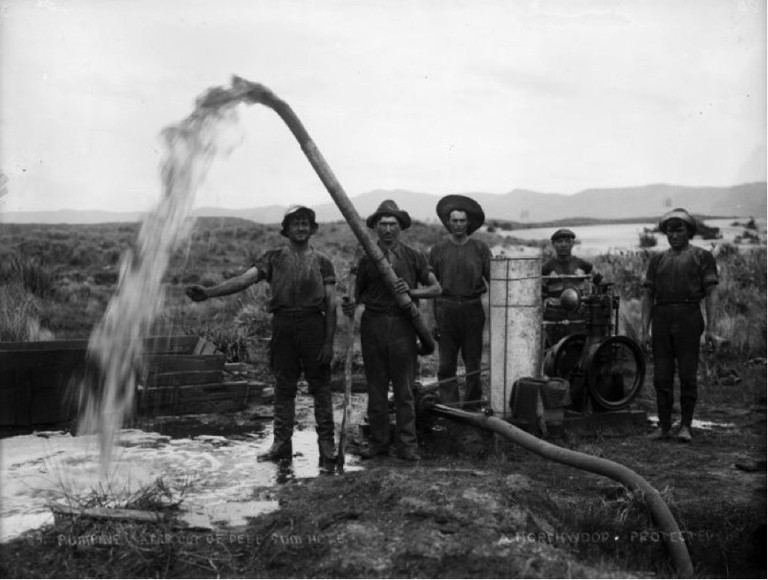 Gum diggers pumping water out of gum hole [ca.1910]. Northwood brothers: Photographs of Northland. Ref: 1/1-006274-G. Alexander Turnbull Library, Wellington, New Zealand. http://natlib.govt.nz/records/22728446. Permission of the Alexander Turnbull Library, Wellington, New Zealand, must be obtained before any reuse of this image.