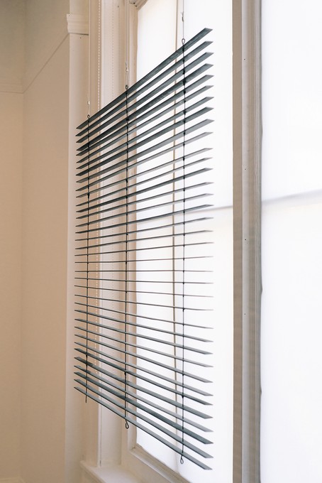 Foreground: Katrina Beekhuis, Fixed blind, 2018, mild steel, clear coat spray paint, panel wire, silicone tubing, epoxy putty. Background: Katrina Beekhuis, Window screen inserts, 2019, translucent roller blind fabric, aluminium, rivets. Image courtesy of Xander Dixon.