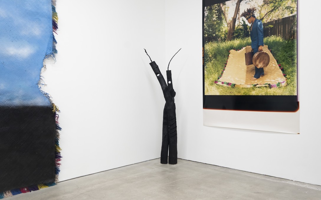 Telly Tuita, Screaming Idol series (driftwood & acrylic paint), 2026 and Alien Arrival (photograph), 2001. Photo by Samson Dell.